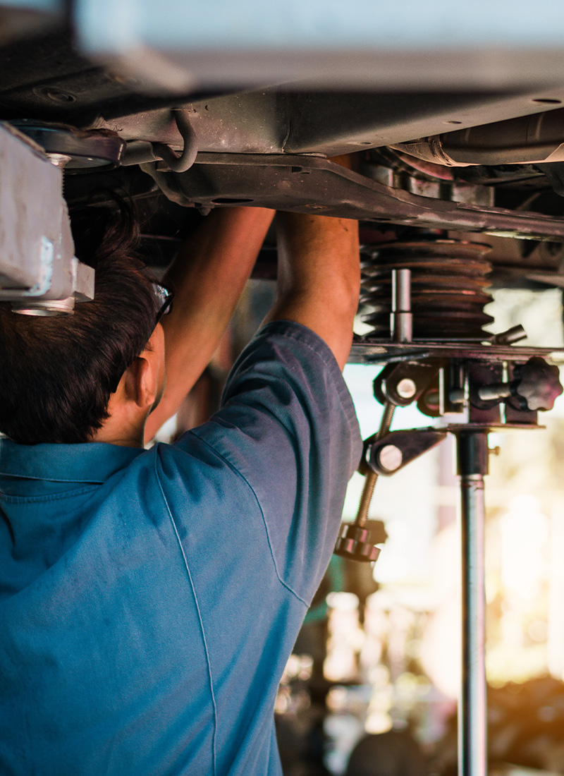 mechanic working under vehicle using tools to repair suspension system for improved performance and safety 6 repairs maintenance